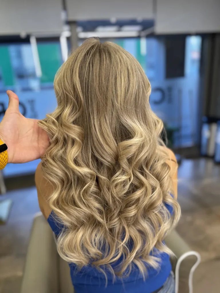Balayage blond auriu pe păr lung, ondulat, realizat la The Crib Hair Studio București